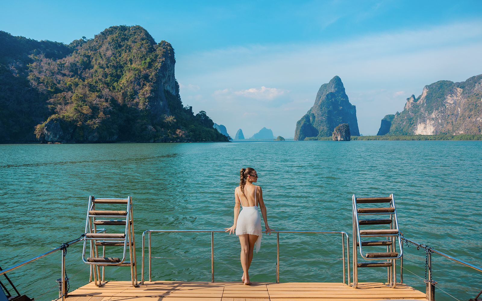 Tourist enjoying view from cruise deck in Phang Nga Bay, Thailand.