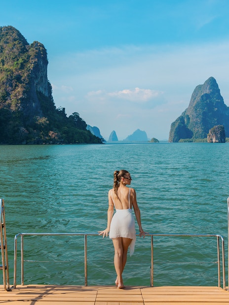Tourist enjoying view from cruise deck in Phang Nga Bay, Thailand.