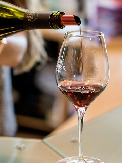 Pouring red wine into a glass at a Chateauneuf du Pape tasting in Provence.