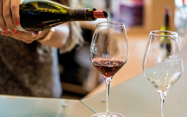 Pouring red wine into a glass at a Chateauneuf du Pape tasting in Provence.