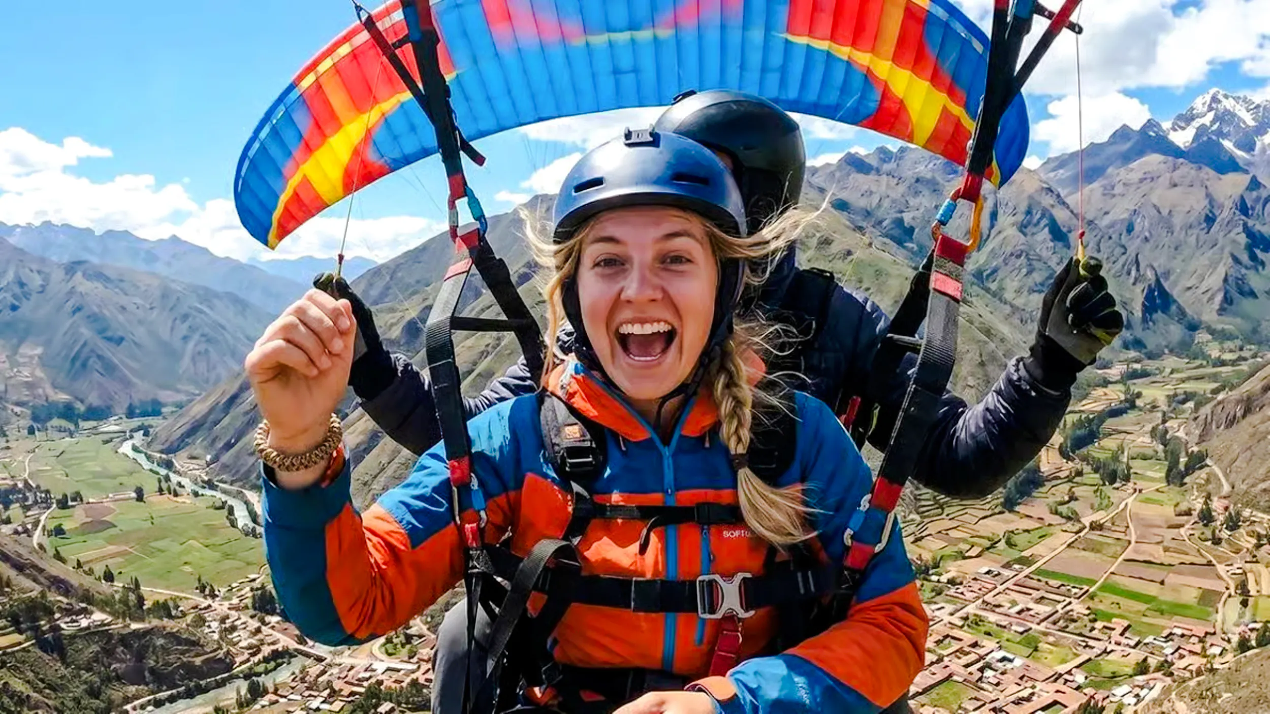 Paragliding over Sacred Valley with mountains and fields below, Cusco.