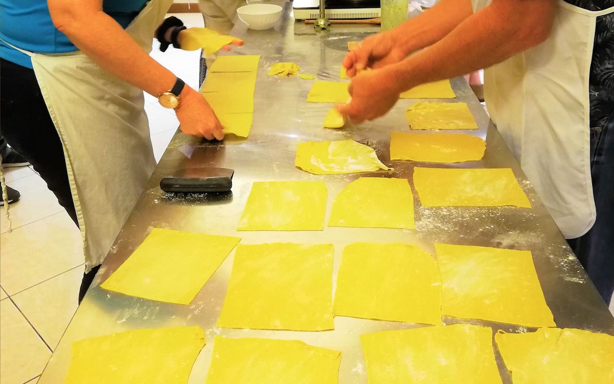 People preparing pasta sheets during a cooking class in Florence.
