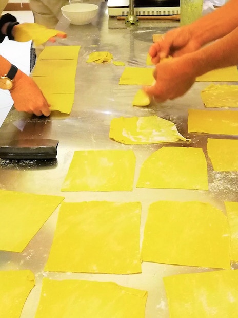 People preparing pasta sheets during a cooking class in Florence.
