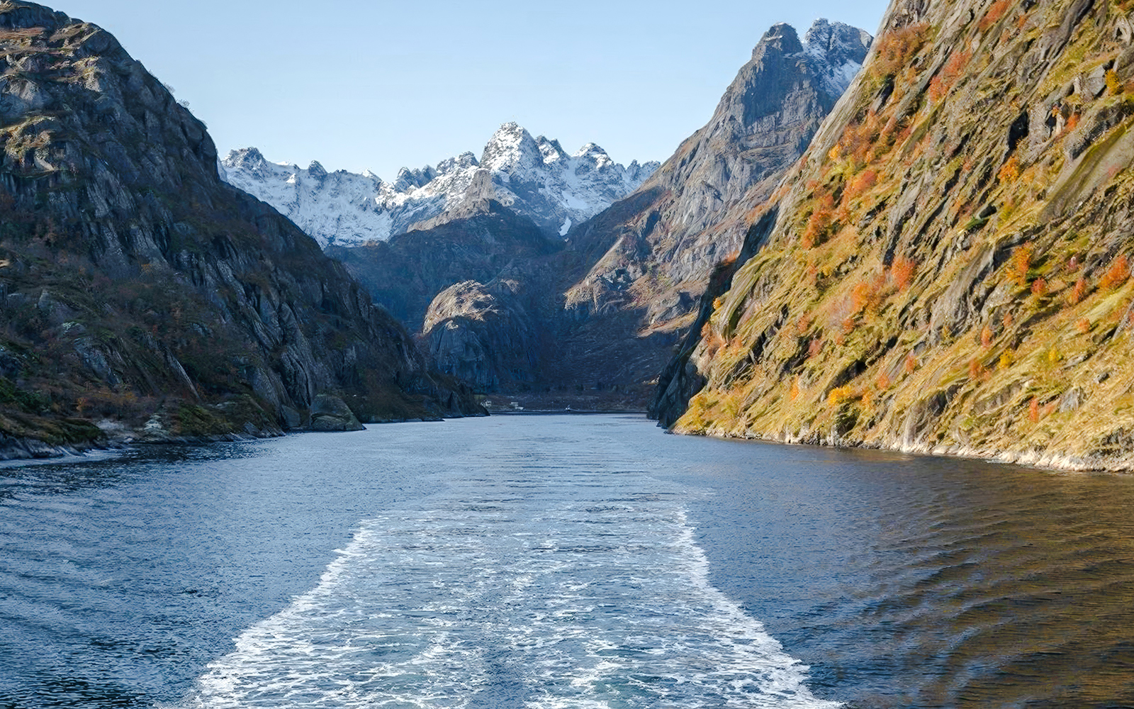 Cruise view of steep cliffs and snowy peaks in Silent Trollfjord, Lofoten.