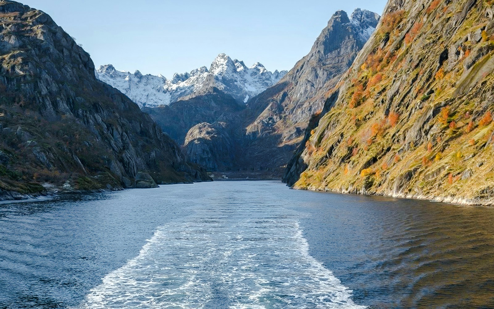 Cruise view of steep cliffs and snowy peaks in Silent Trollfjord, Lofoten.