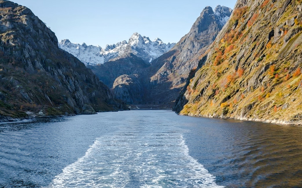 Cruise view of steep cliffs and snowy peaks in Silent Trollfjord, Lofoten.