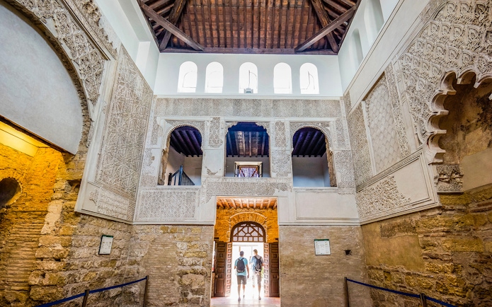 Interior of Cordoba Mosque-Cathedral with intricate arches and stone walls.