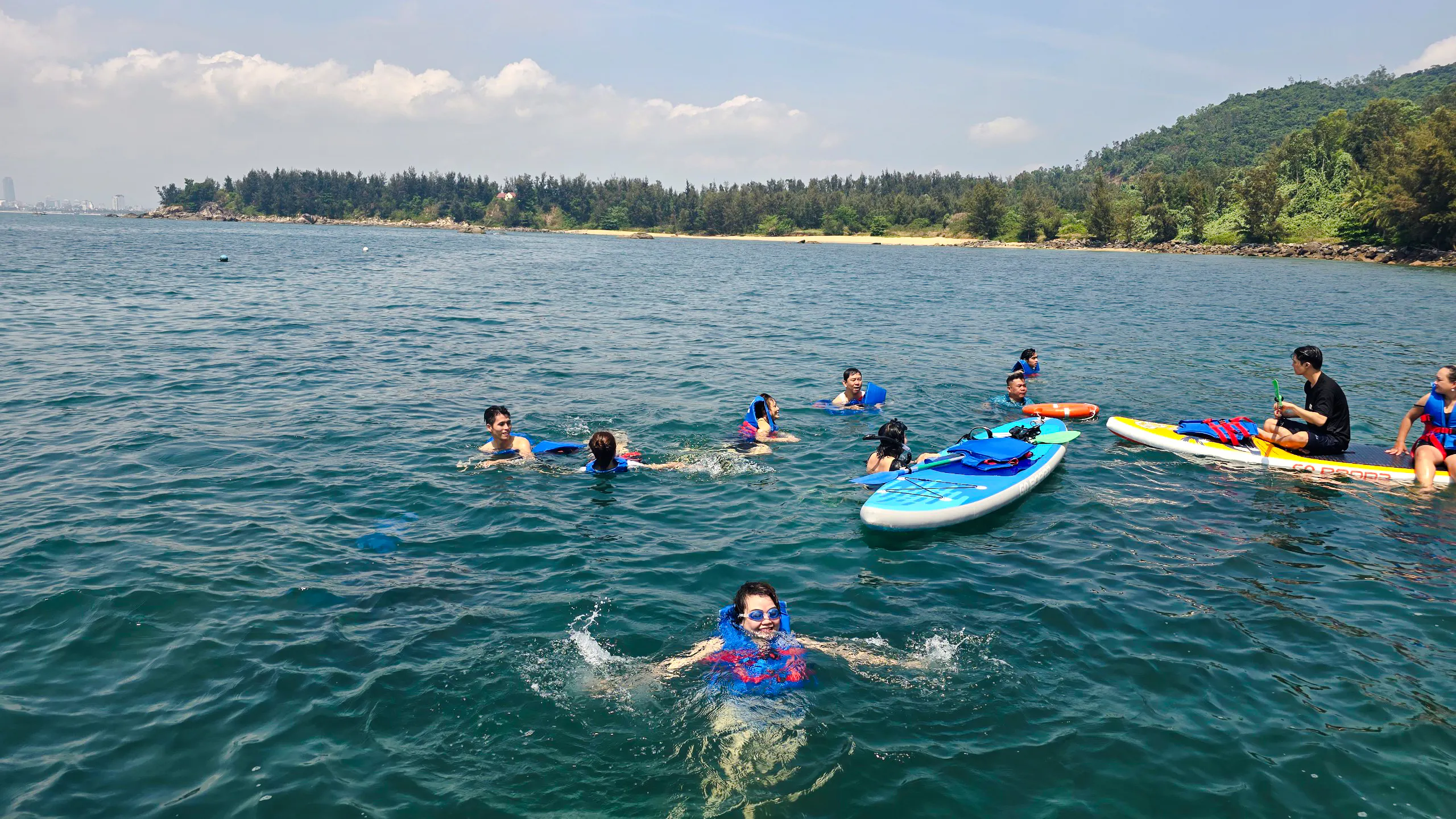 People swimming and paddleboarding during Son Tra Peninsula cruise, Da Nang.