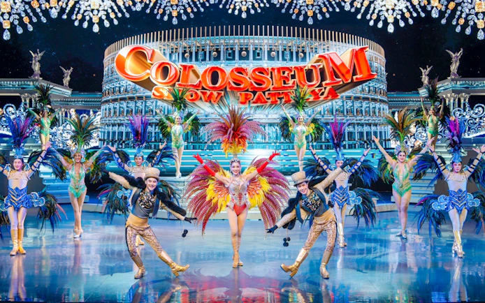 Performers in vibrant costumes on stage at Colosseum Cabaret Show Pattaya.