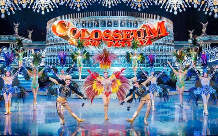 Performers in vibrant costumes on stage at Colosseum Cabaret Show Pattaya.