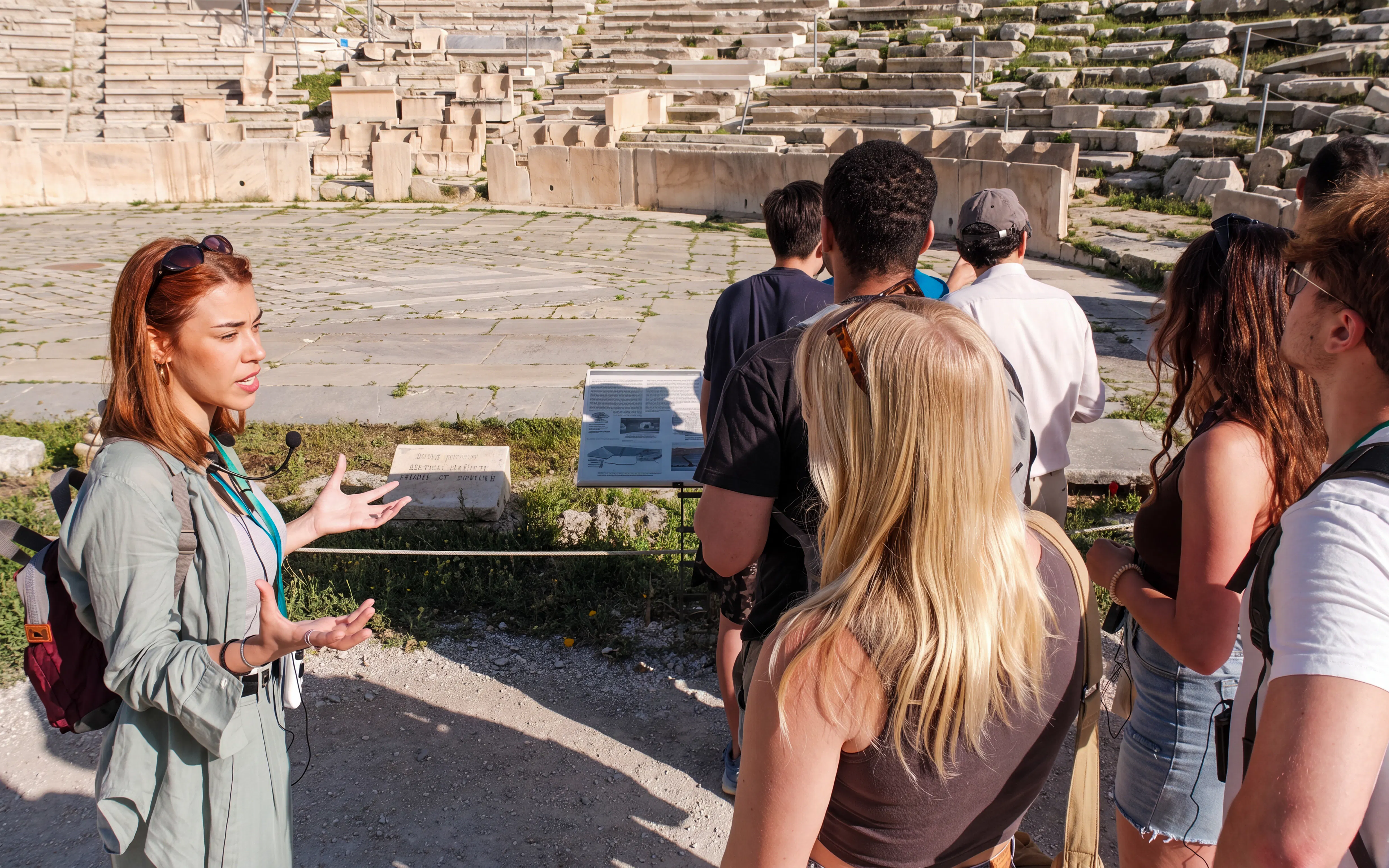 Tour guide explaining the history of the Acropolis to a group of visitors in Athens.