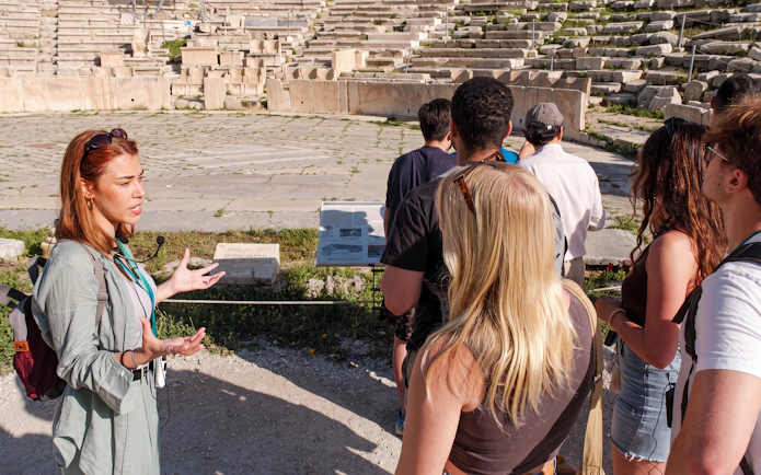 Tour guide explaining the history of the Acropolis to a group of visitors in Athens.
