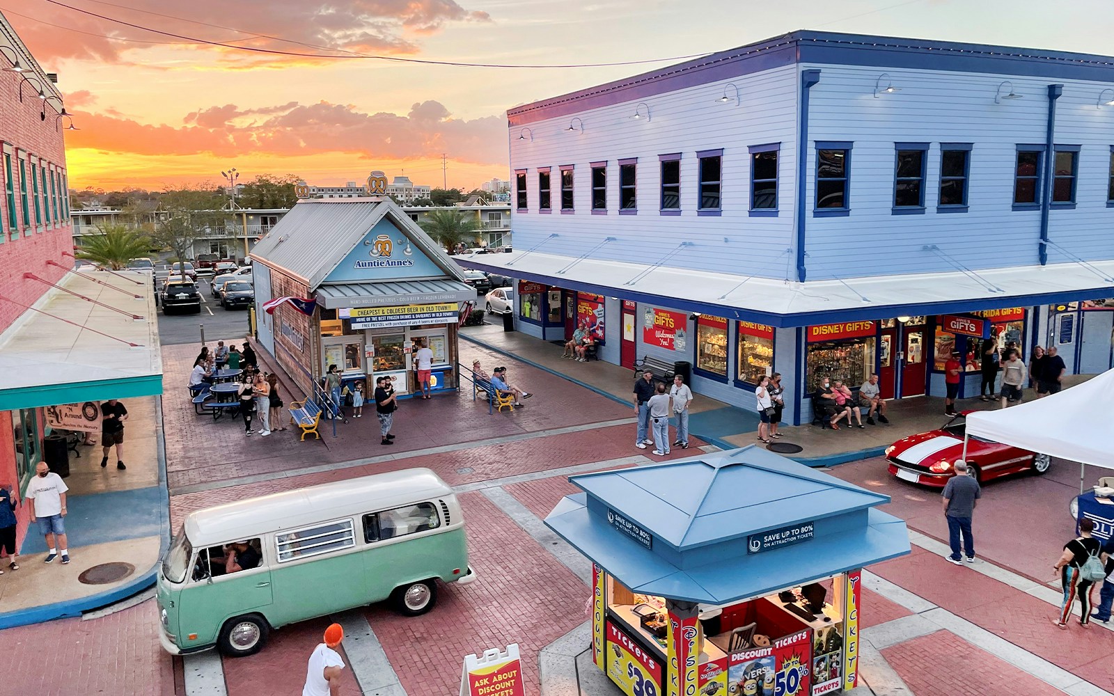Old Town Orlando at sunset with shops, visitors, and a vintage van in the plaza.