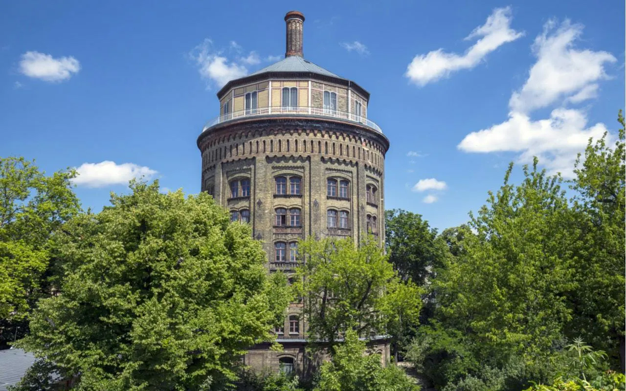 Historic water tower in Berlin's Jewish District surrounded by trees.