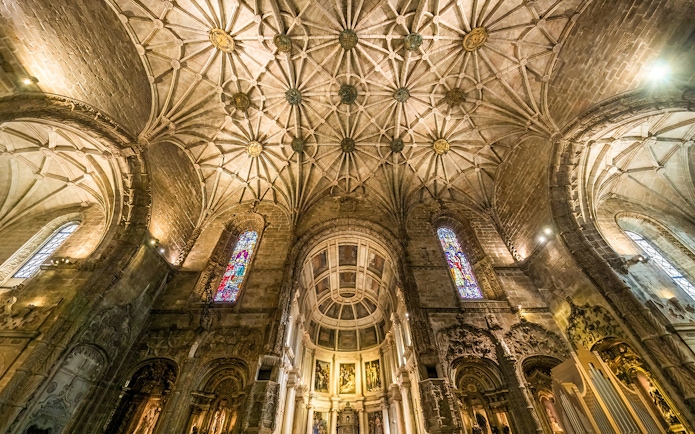 Jernimos Monastery interior with vaulted ceiling and stained glass windows in Lisbon, Portugal.