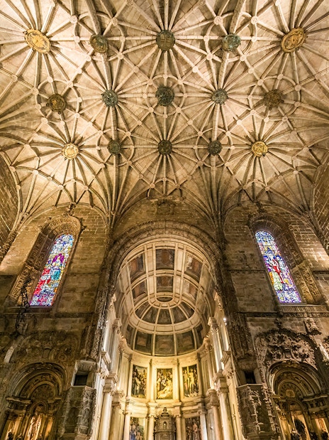 Jernimos Monastery interior with vaulted ceiling and stained glass windows in Lisbon, Portugal.