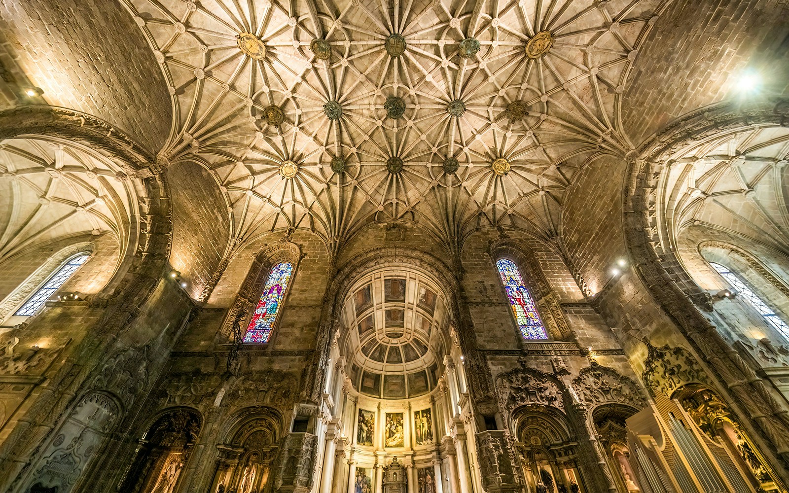 Jernimos Monastery interior with vaulted ceiling and stained glass windows in Lisbon, Portugal.