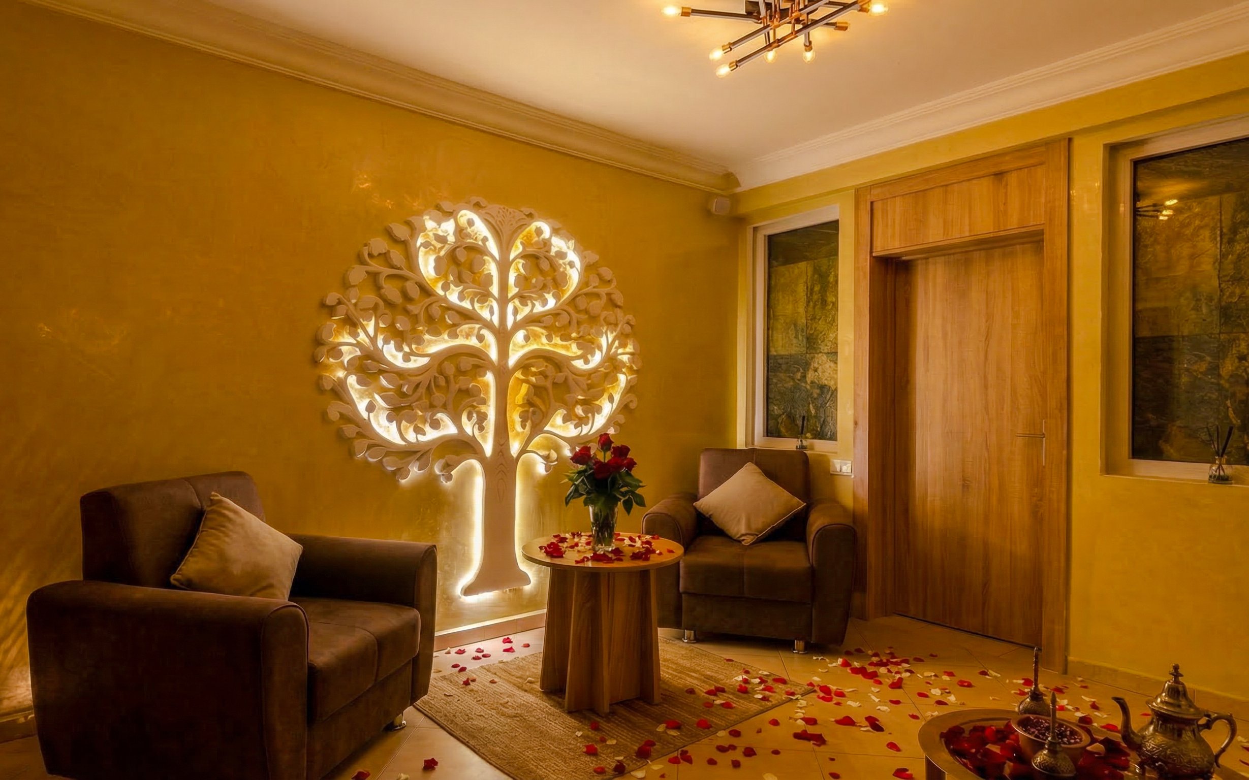 Luxurious Moroccan hammam room with ornate wall decor and rose petals.