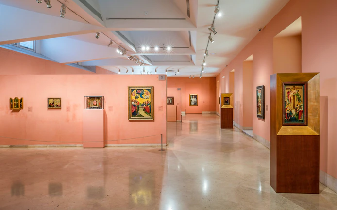 Thyssen Bornemisza Museum gallery with diverse paintings on pink walls.