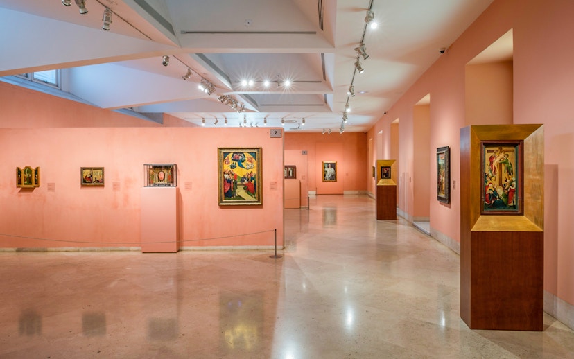 Thyssen Bornemisza Museum gallery with diverse paintings on pink walls.