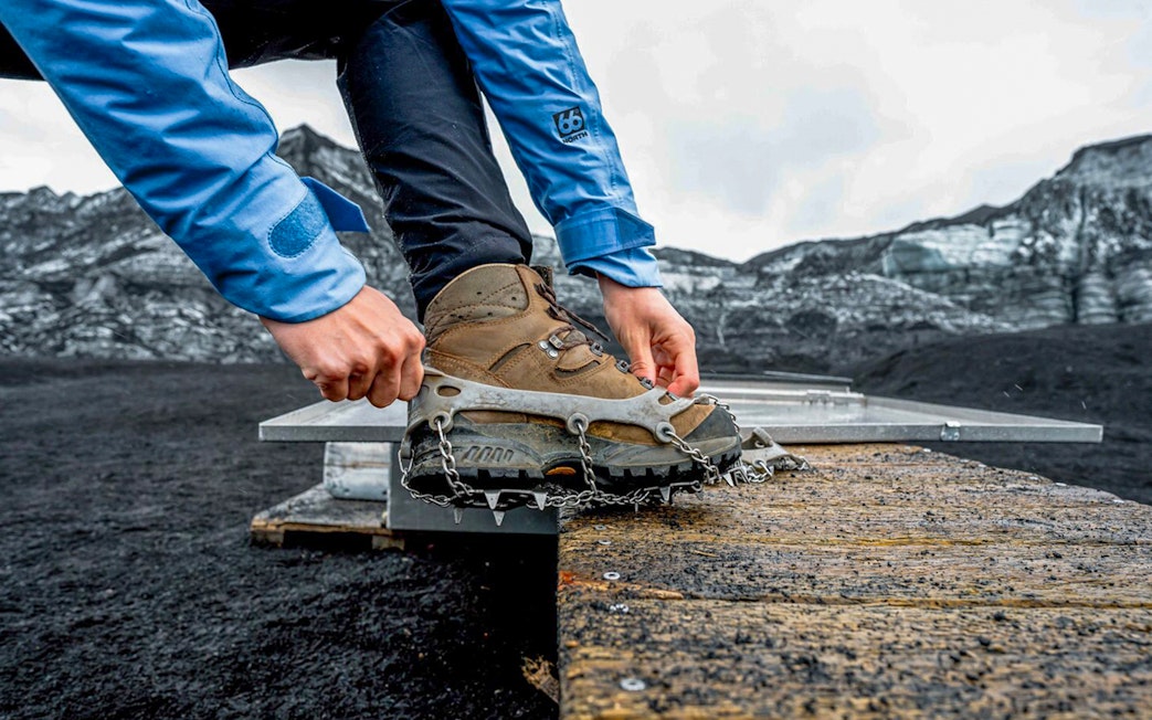 Guest fastening crampons for Katla Ice Cave and super jeep tour in Iceland.