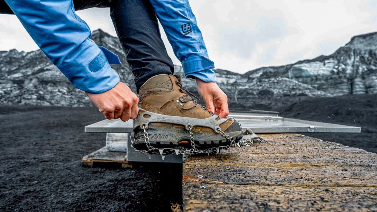 Guest fastening crampons for Katla Ice Cave and super jeep tour in Iceland.