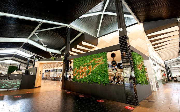 Crikey Cafe entrance at Australia Zoo with green plant wall and modern interior.