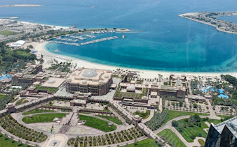 Aerial view of Emirates Palace and marina in Abu Dhabi during a full-day private city tour.