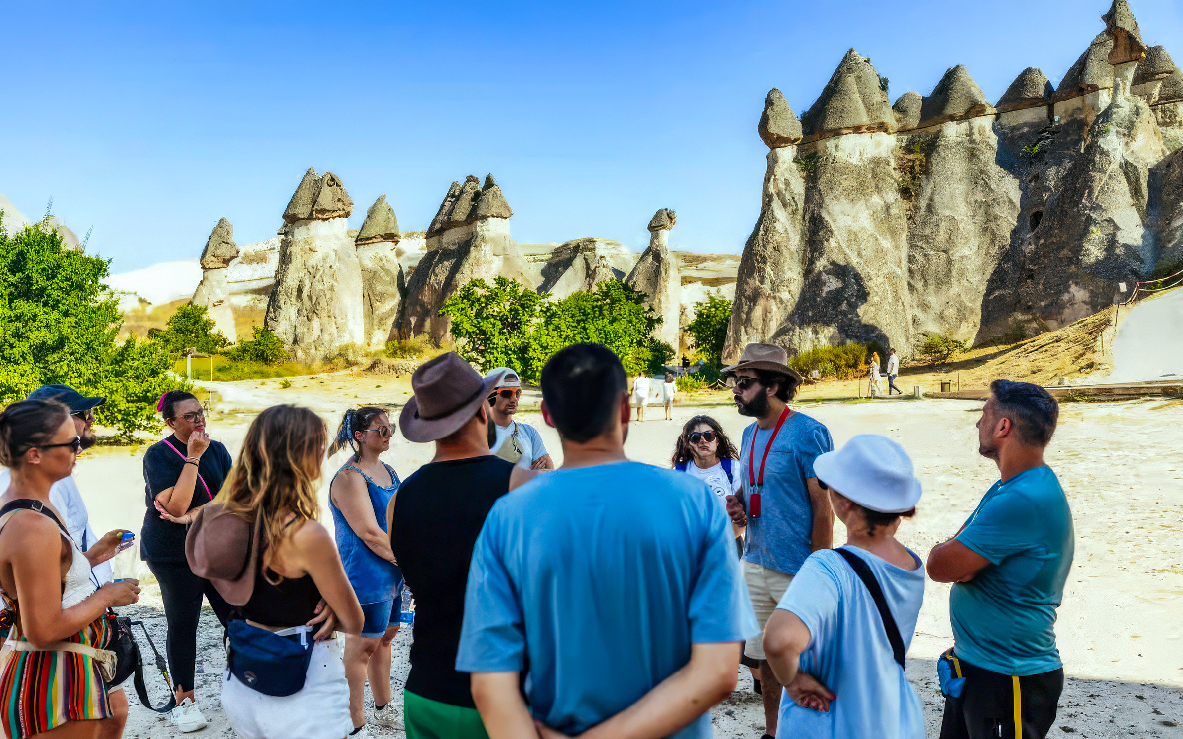 Tourists with a guide in front of fairy chimneys in Göreme, Cappadocia.