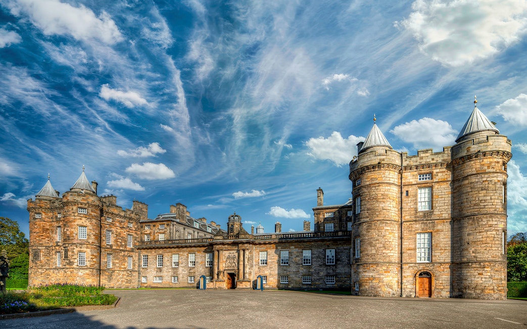 Palace of Holyroodhouse in Edinburgh with blue sky and clouds.