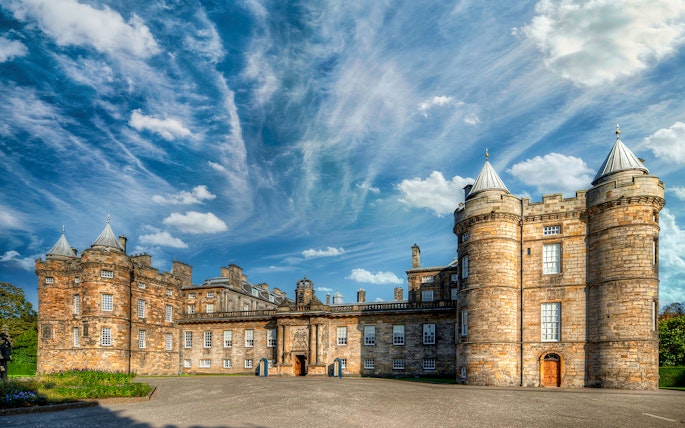 Palace of Holyroodhouse in Edinburgh with blue sky and clouds.
