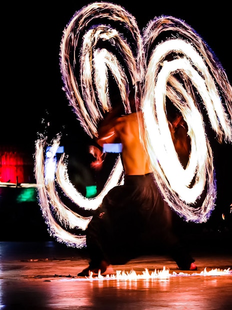Fire dancer performing at night during Dubai desert safari tour.