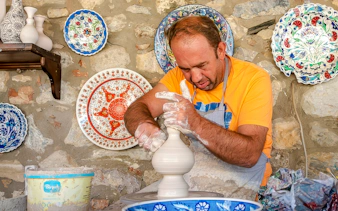 Pottery artist shaping clay on a wheel during Cappadocia Authentic Pottery Workshop Experience.