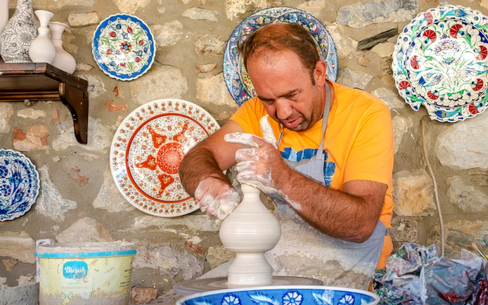 Pottery artist shaping clay on a wheel during Cappadocia Authentic Pottery Workshop Experience.
