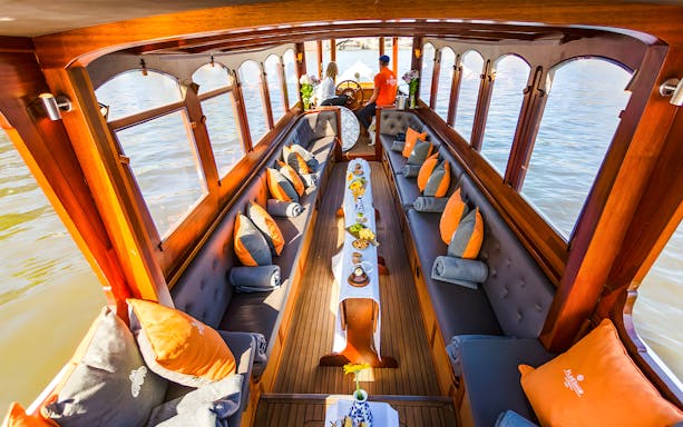 Saloon boat interior with seating and table setup, Amsterdam canal view.