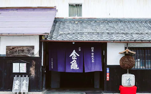Entrance of Okamura Honke Sake Brewery in Shiga with traditional signage and decor.
