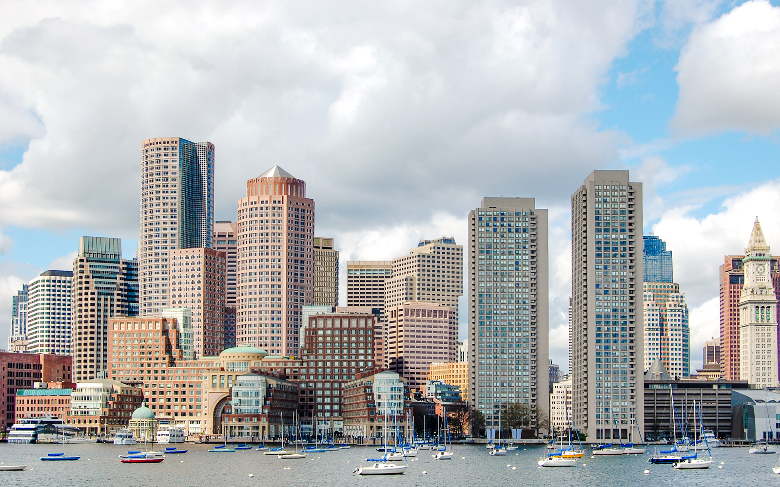 Boston downtown waterfront skyline with sailboats on the harbor.