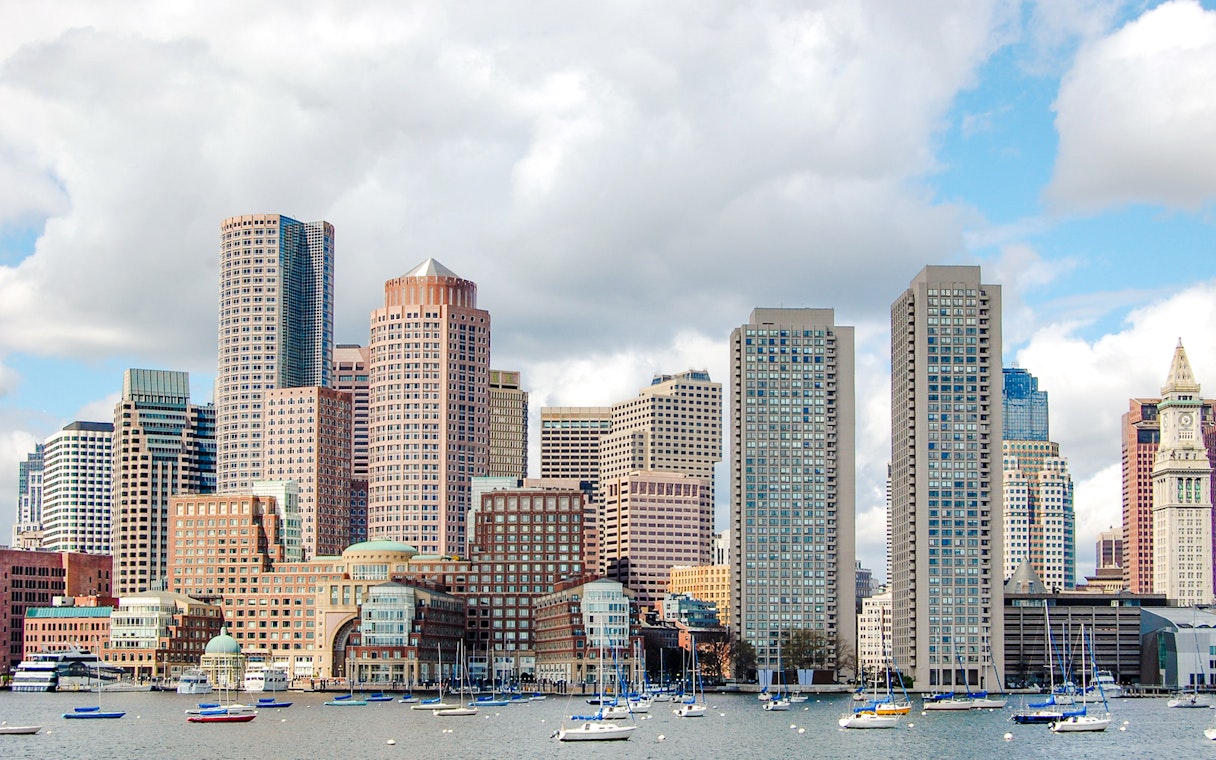 Boston downtown waterfront skyline with sailboats on the harbor.
