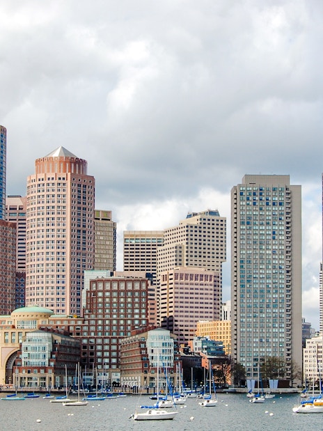 Boston downtown waterfront skyline with sailboats on the harbor.