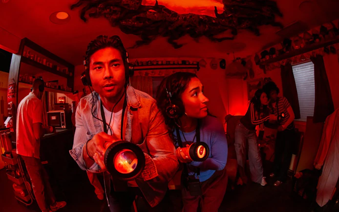 Visitors exploring a Stranger Things-themed room with flashlights at Netflix house, Dallas.