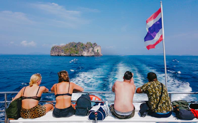 Tourists on a cruise ship in the Andaman Sea with an island in the distance.