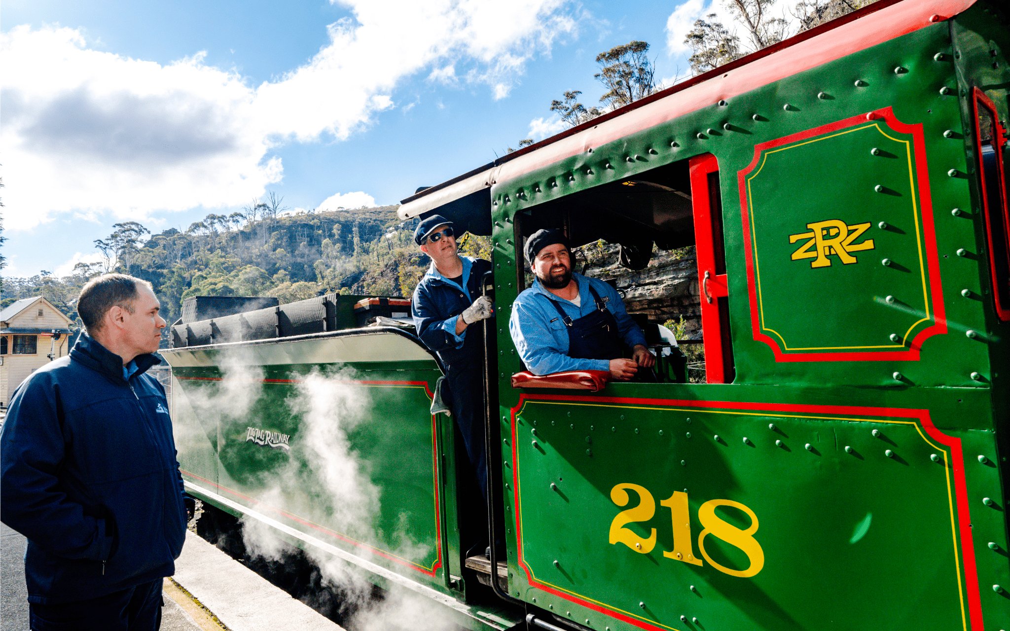 Historic steam train at Blue Mountains Zig Zag Railway with crew and passenger.