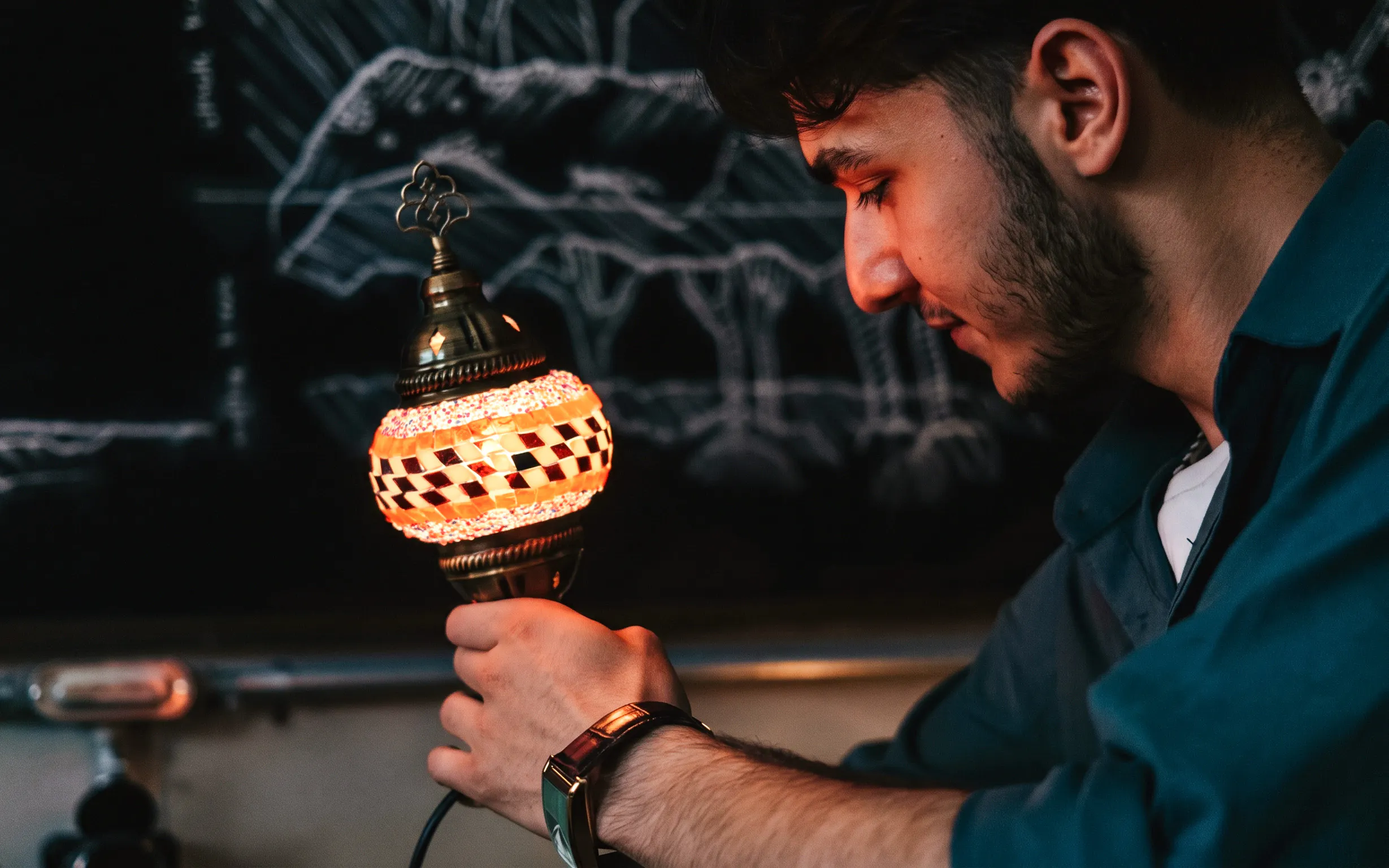 Guest holding a mosaic lamp at Istanbul Turkish Mosaic Lamp Workshop.