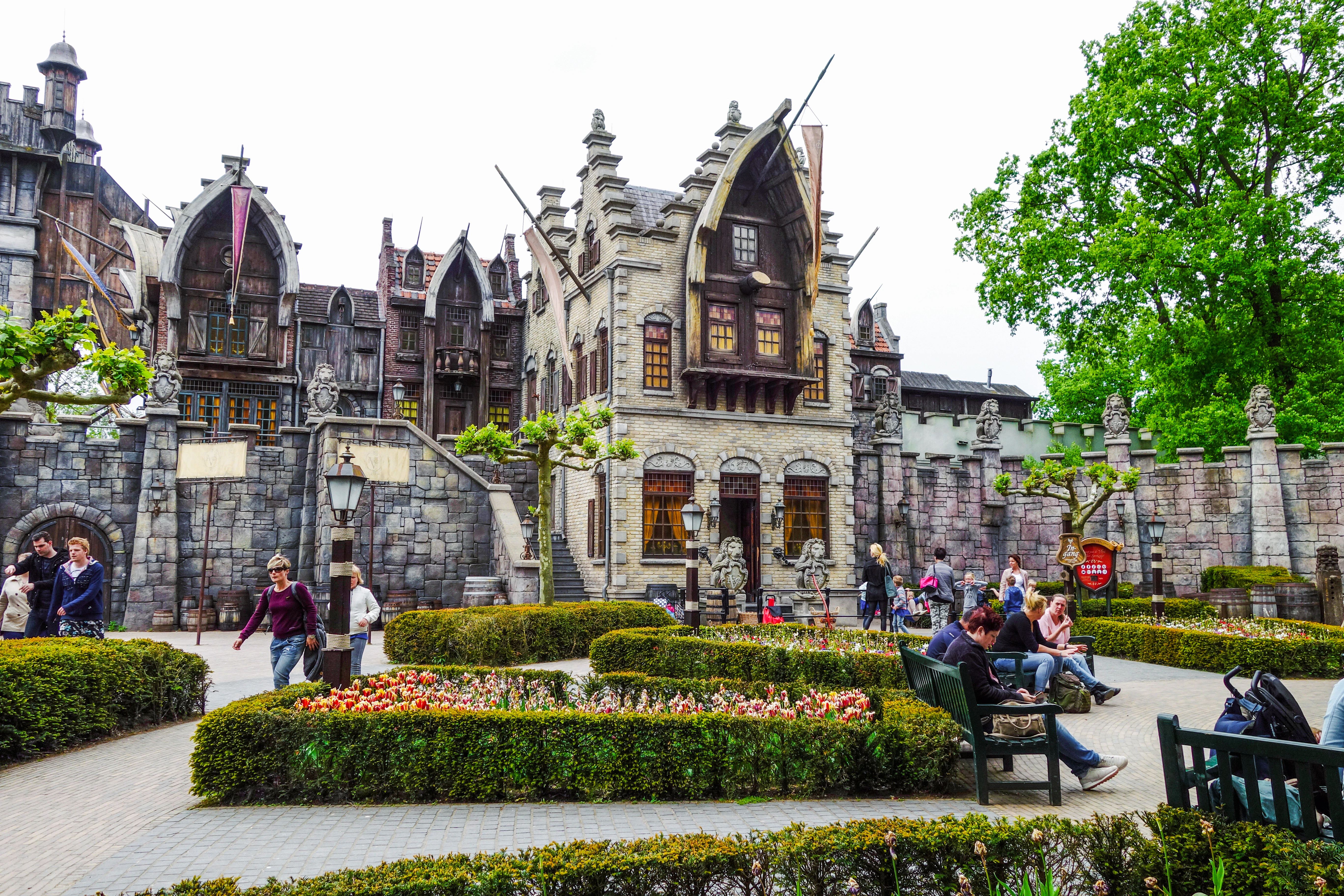 Efteling amusement park with fantasy-themed architecture and visitors strolling through gardens.