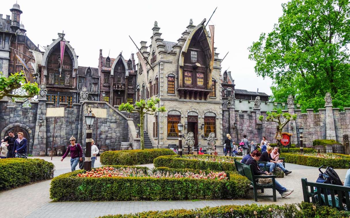 Efteling amusement park with fantasy-themed architecture and visitors strolling through gardens.