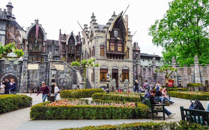 Efteling amusement park with fantasy-themed architecture and visitors strolling through gardens.