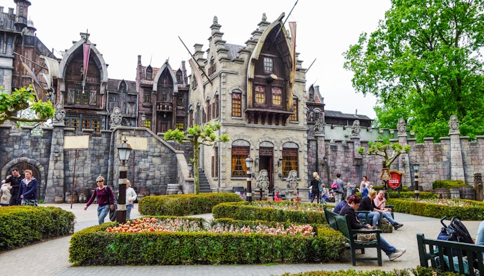 Efteling amusement park with fantasy-themed architecture and visitors strolling through gardens.
