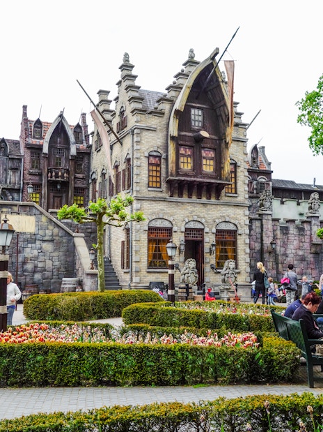 Efteling amusement park with fantasy-themed architecture and visitors strolling through gardens.