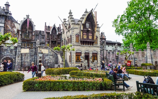 Efteling amusement park with fantasy-themed architecture and visitors strolling through gardens.