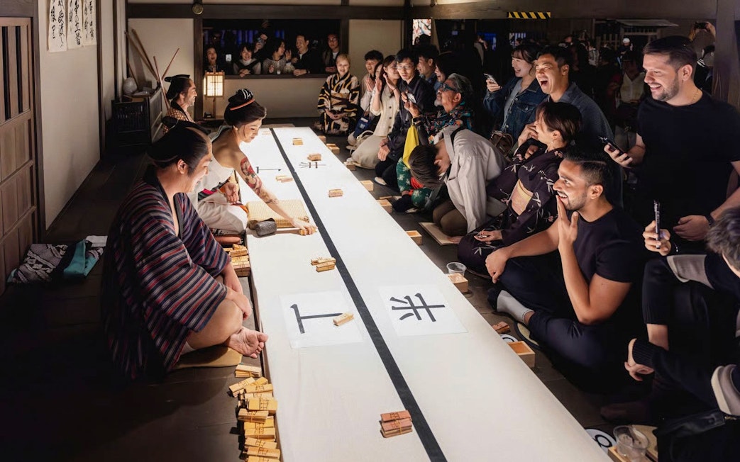Tourists enjoying a traditional game at TOEI Kyoto Studio Park.